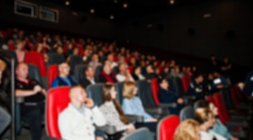 Blured photo of audience peoples in the cinema.